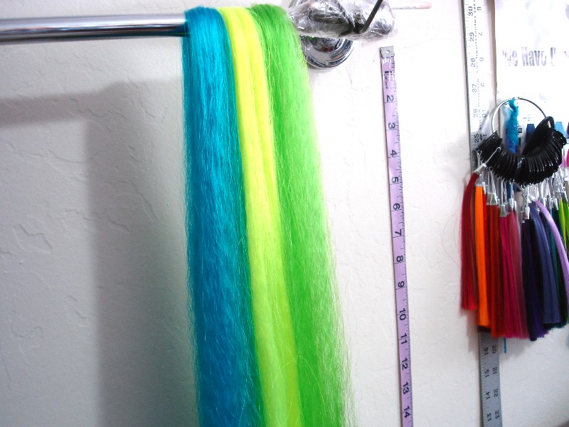 Image: Blue, yellow, and green hair hanging on a rack